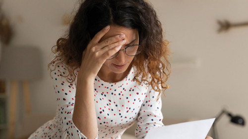 Confused young female open official letter about loan rejection