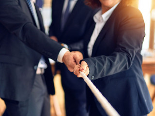 Business workers stretching rope at the office