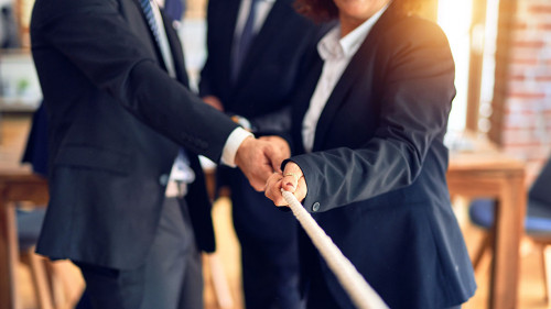 Business workers stretching rope at the office