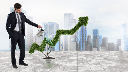 Businessman that watering a plant with a shape of arrow. Concept of growing of company economy .