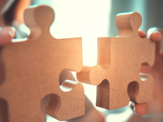 Silhouette of woman connecting jigsaw puzzle with sunlight effec