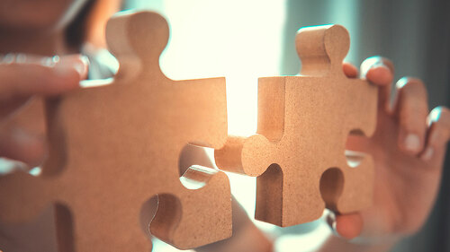 Silhouette of woman connecting jigsaw puzzle with sunlight effec