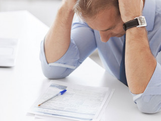 stressed businessman with papers at work