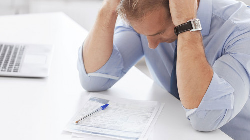 stressed businessman with papers at work