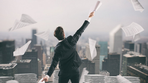 Businessman tired of bureaucracy throws up sheets of paper in the air