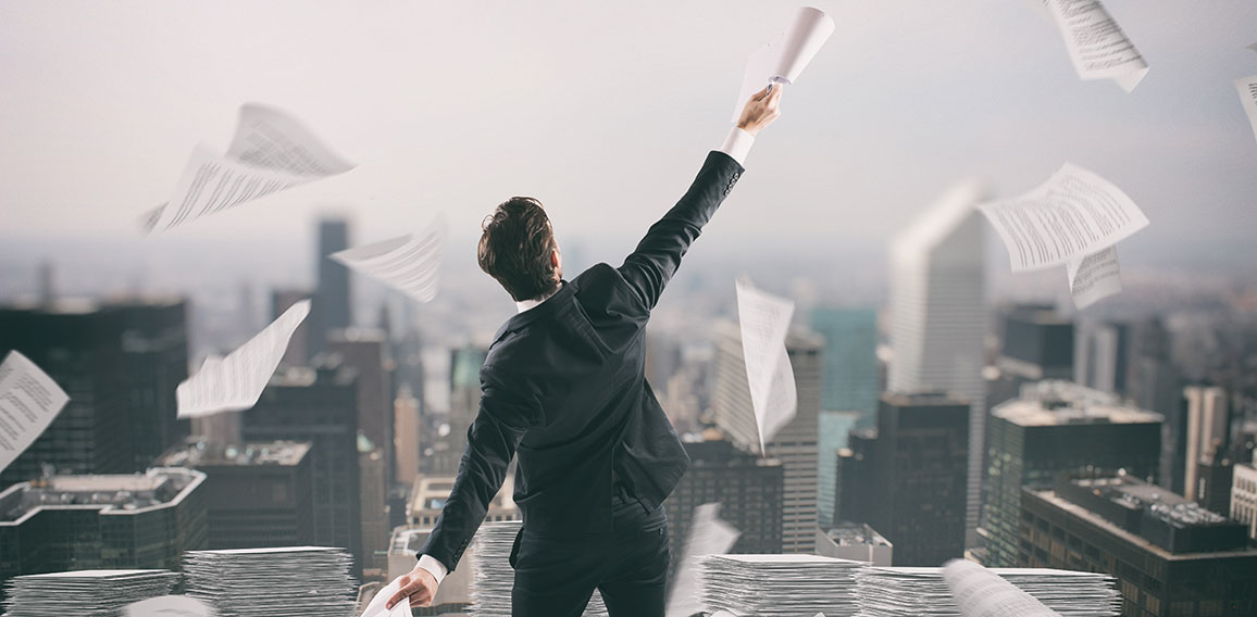 Businessman tired of bureaucracy throws up sheets of paper in the air