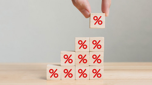 Interest rate financial and mortgage rates concept. Hand putting wood cube block increasing on top with icon percentage symbol upward direction