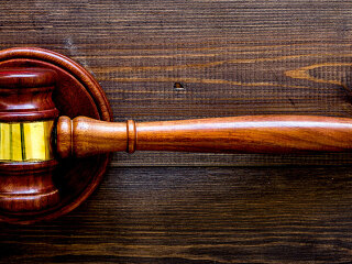 Car accident lawsuit concept. Two collided cars near judge gavel on dark wooden background top view copy space