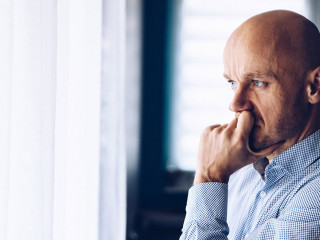 Worried businessman in office. Thoughtful man looking through the window.