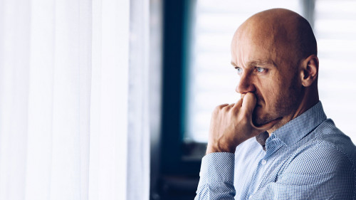 Worried businessman in office. Thoughtful man looking through the window.