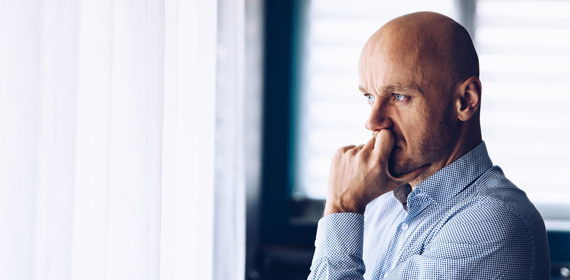 Worried businessman in office. Thoughtful man looking through the window.