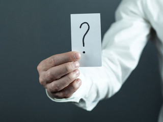 Man holding paper with question mark.