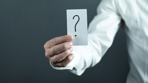 Man holding paper with question mark.