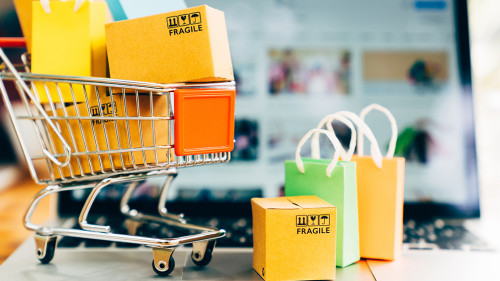 Product package boxes and shopping bag in cart with laptop compu