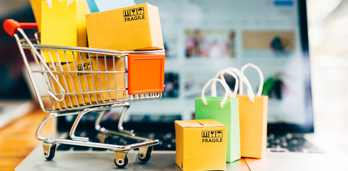 Product package boxes and shopping bag in cart with laptop compu