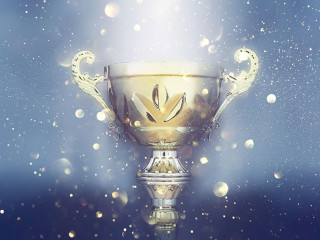 sports concept low key image of gold trophy over dark smoky background and glitter lights