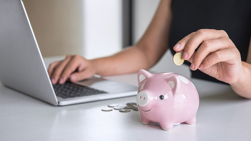 Woman putting golden coin in pink piggy bank for step up growing