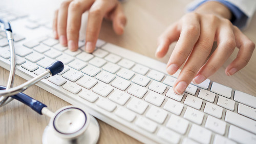 Female doctor typing on computer
