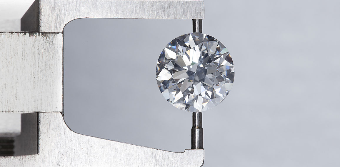 loose big brilliant round diamond is being measure by mm gauge a