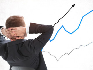 Confident businessman looking at rising graphs