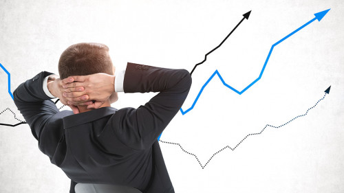 Confident businessman looking at rising graphs