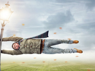 Mann im Sturm hängt an einer Laterne