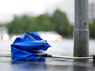 After a strong storm a broken umbrella is lying on the street