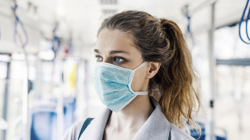 Woman wearing surgical protective mask in a public transportatio