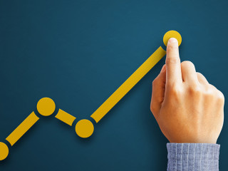 Businessman is touching arrows pointing up with graph as a symbo