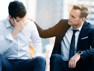 Two Caucasian businessmen sit in city. Unemployment concerns And