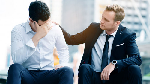 Two Caucasian businessmen sit in city. Unemployment concerns And