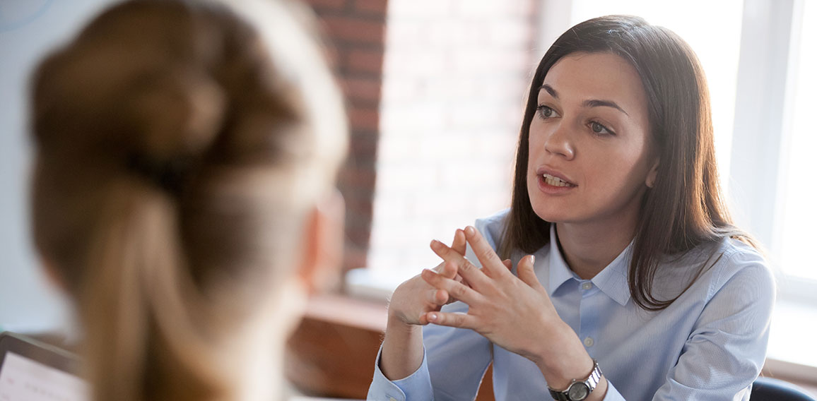 Confident focused businesswoman speaking to people at business n