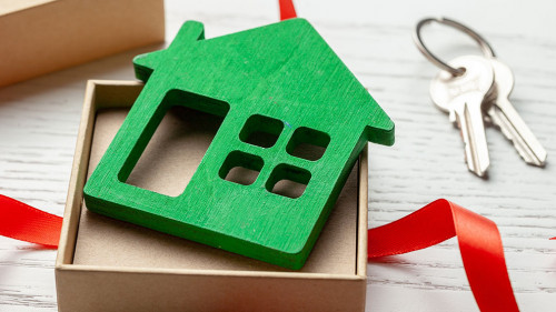 Gift box with red ribbon and house with keys. House as a gift