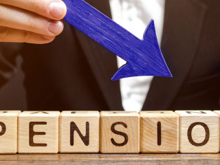 A man holds an arrow down over wooden blocks with the word Pension. Fall / reduction pension payments. Retirement. Financing retirees. Reduction of the pension fund. The low size of pensions.
