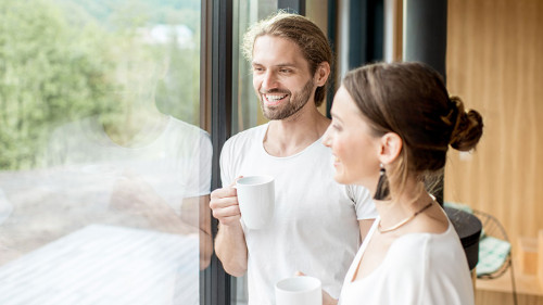 Couple standing near the window indoors