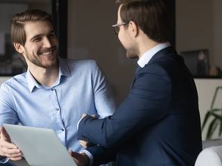Happy colleagues shaking hands, greeting or making agreement in office