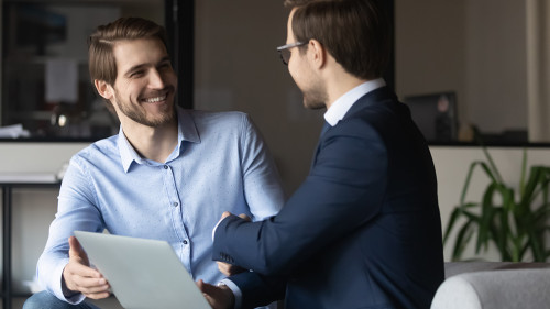Happy colleagues shaking hands, greeting or making agreement in office