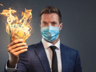 Businessman with a protective face mask is loosing money