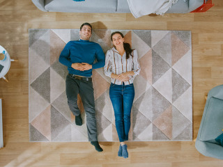 Young Couple is Lying Down on the Floor and Talking. They Point