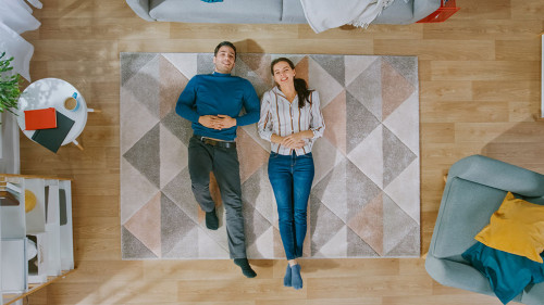 Young Couple is Lying Down on the Floor and Talking. They Point