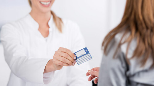 patientin und arzthelferin mit versicherungskarte