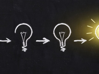 Black and white light bulb using doodle art on chalkboard backgr