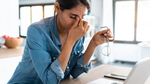 Stressed business woman working from home on laptop looking worr