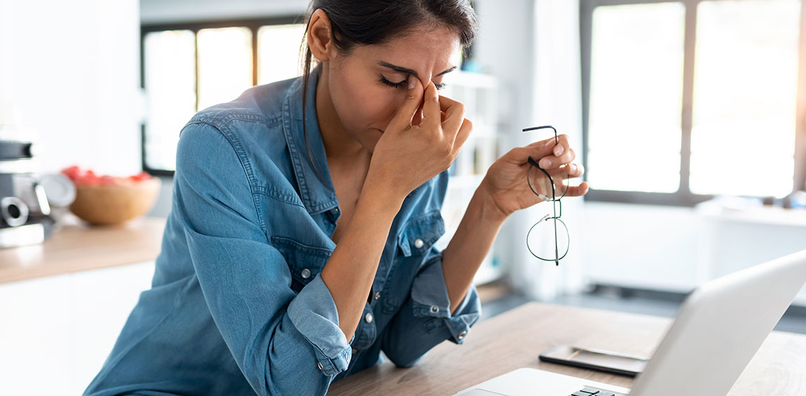 Stressed business woman working from home on laptop looking worr