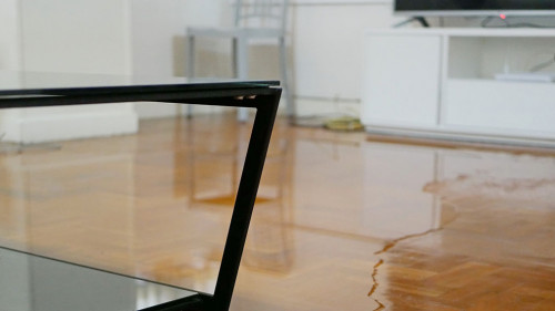 Close up of water flooding on living room parquet floor in a hou