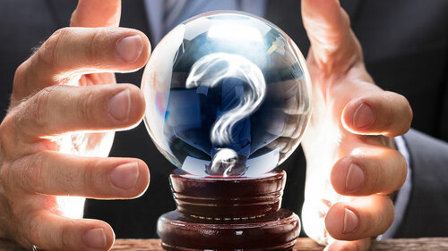 Businessman Covering Crystal Ball With Question Mark