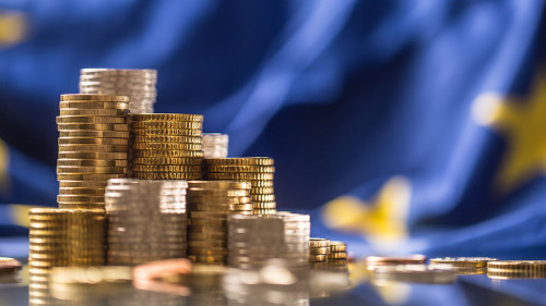 Towers with euro coins and flag of European Union in the background