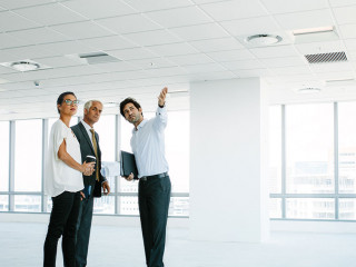Real estate agent showing new office space to clients