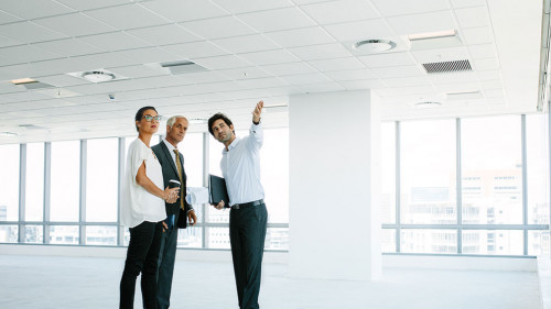 Real estate agent showing new office space to clients