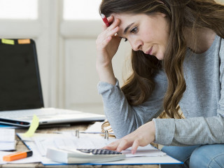 worried woman suffering stress doing domestic accounting paperwo